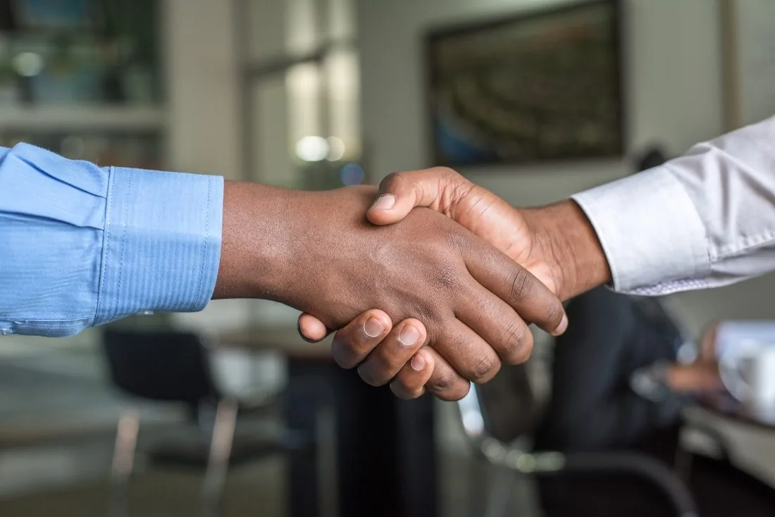 Two business people shaking hands in an office