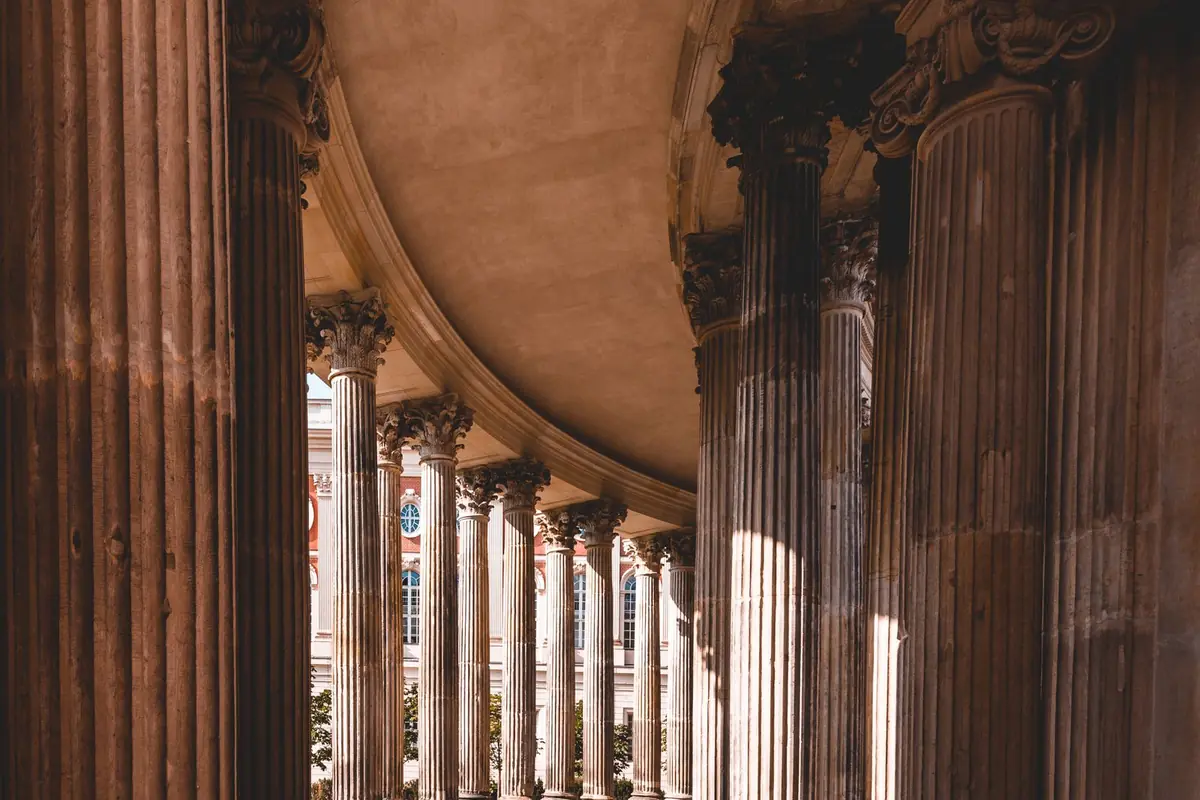 A sunlit corridor of classical stone columns