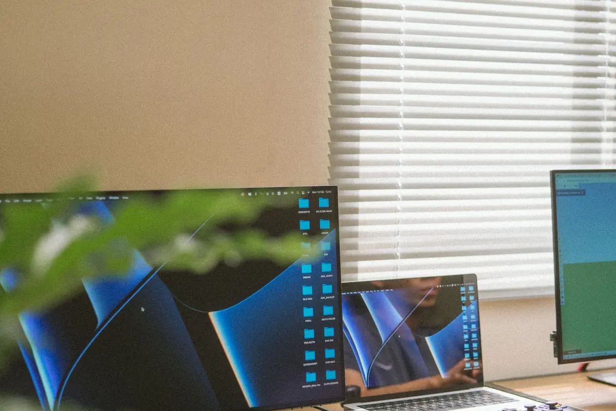 A tidy office desk with a laptop and twin monitors