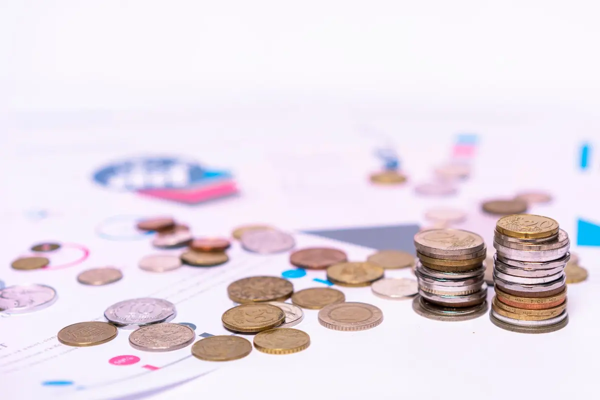 Stacked coins beside financial documents