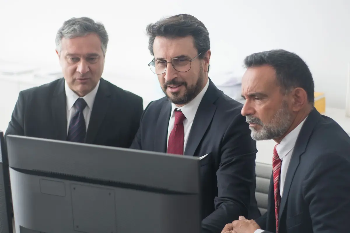 Three professionals working together at office desks