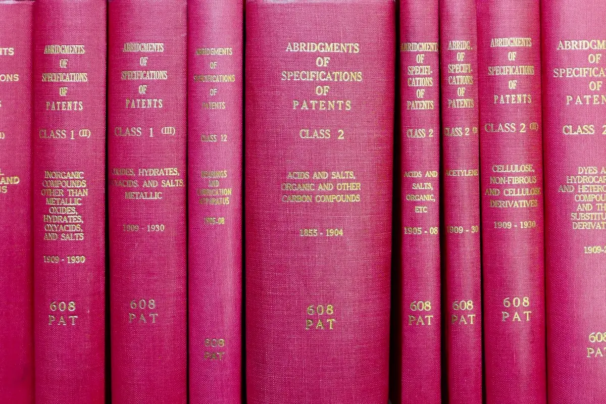 Rows of red hardbound volumes on a library shelf