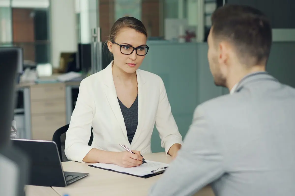Two professionals in a serious meeting across a desk