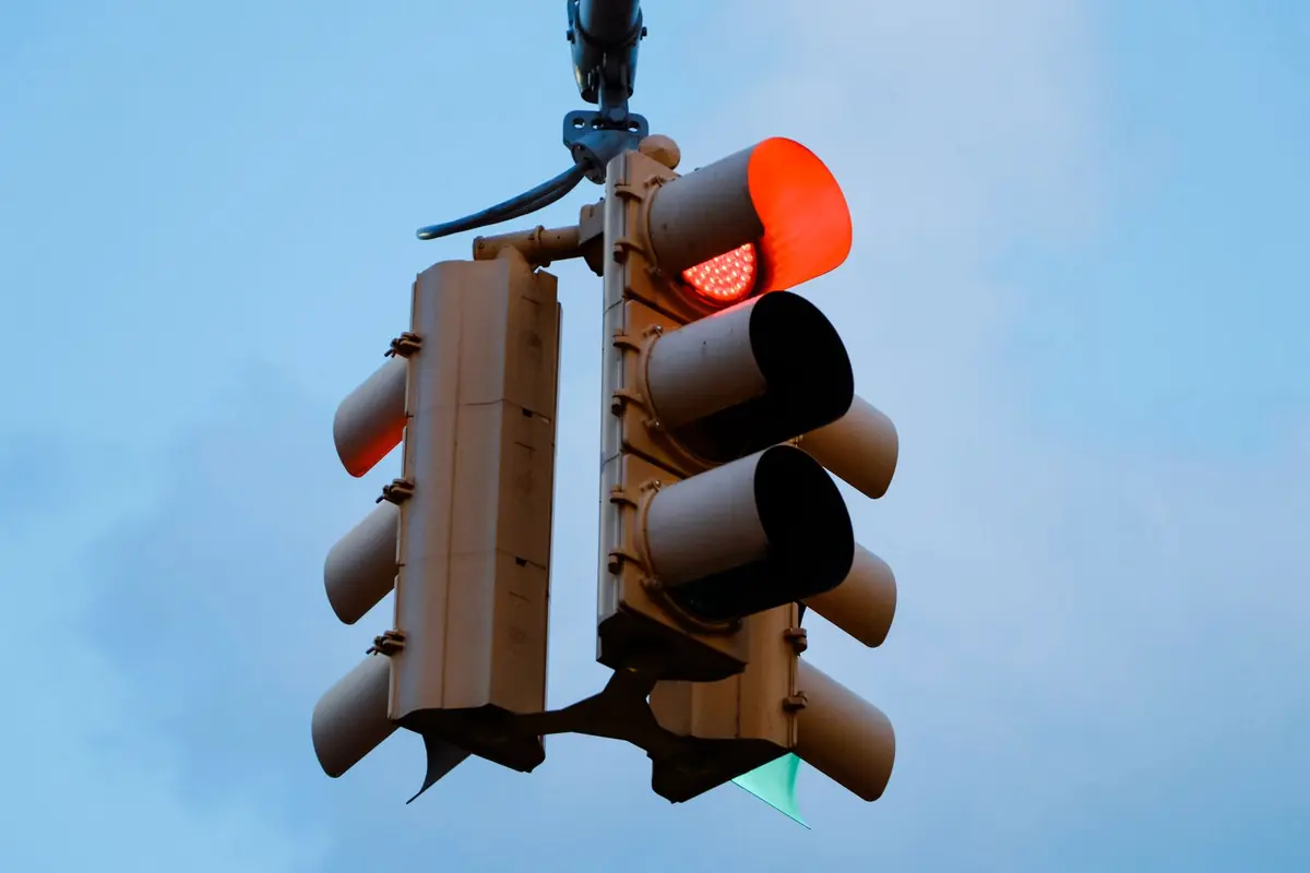 A red traffic light against a clear blue sky