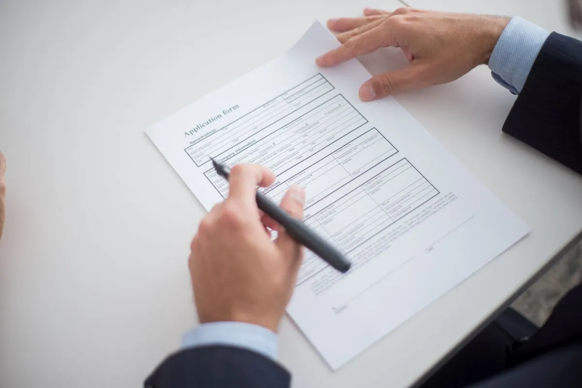An application form being completed across a desk
