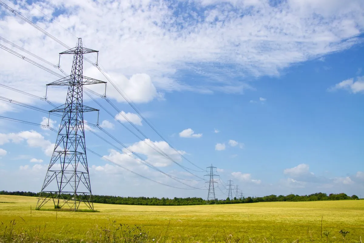 Electricity pylons carrying power lines across an English field