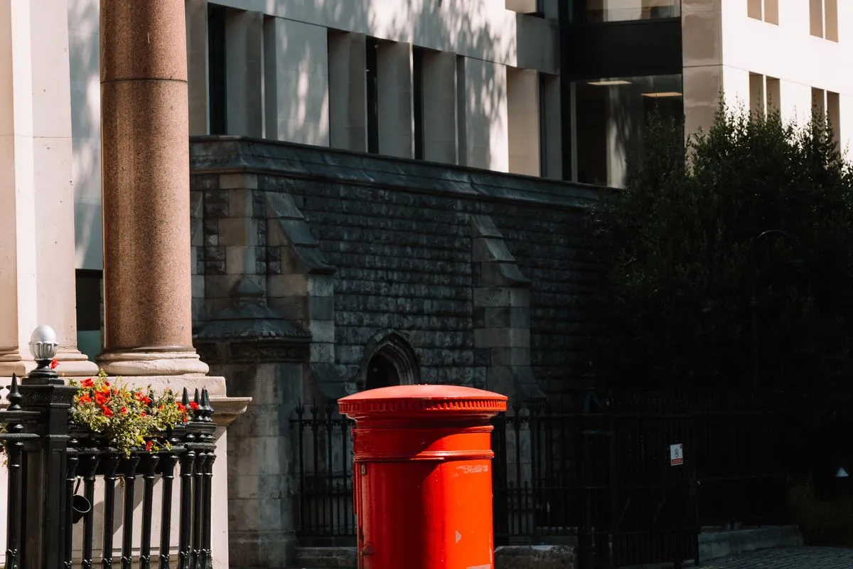 A red pillar box on a London street of stone buildings