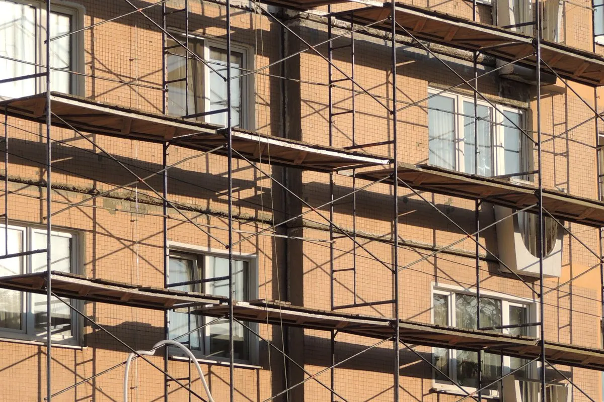 Scaffolding rising across the front of a brick building