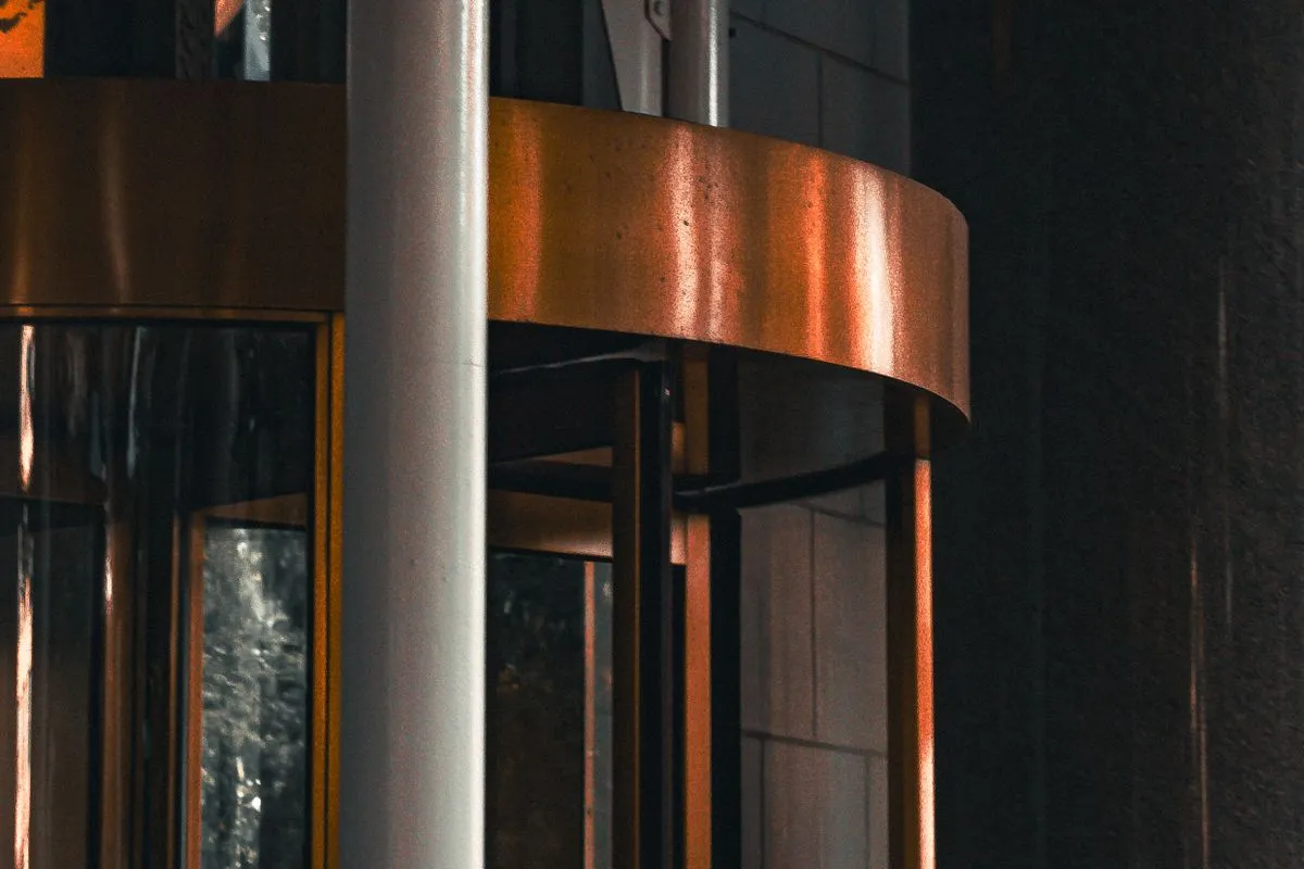 A brass and glass revolving door at a building entrance