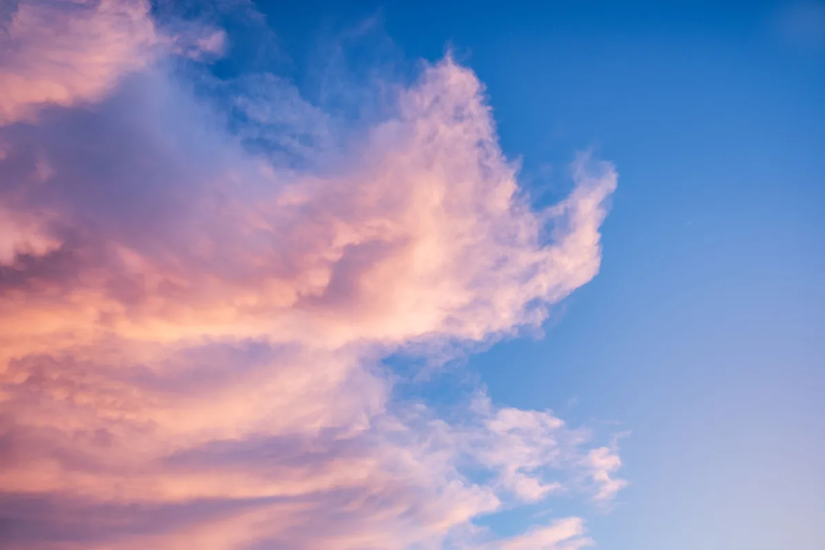 Pink clouds against a deep blue sky