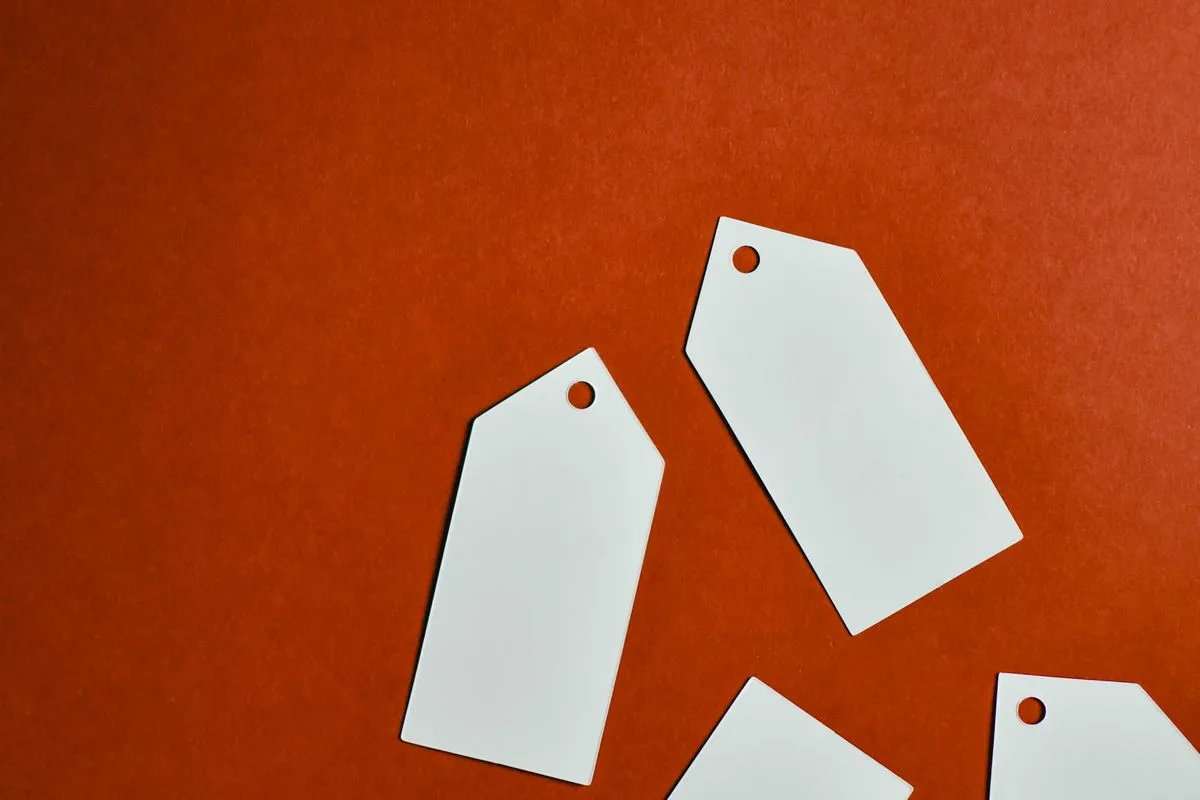 Blank white price tags scattered across a bright red surface